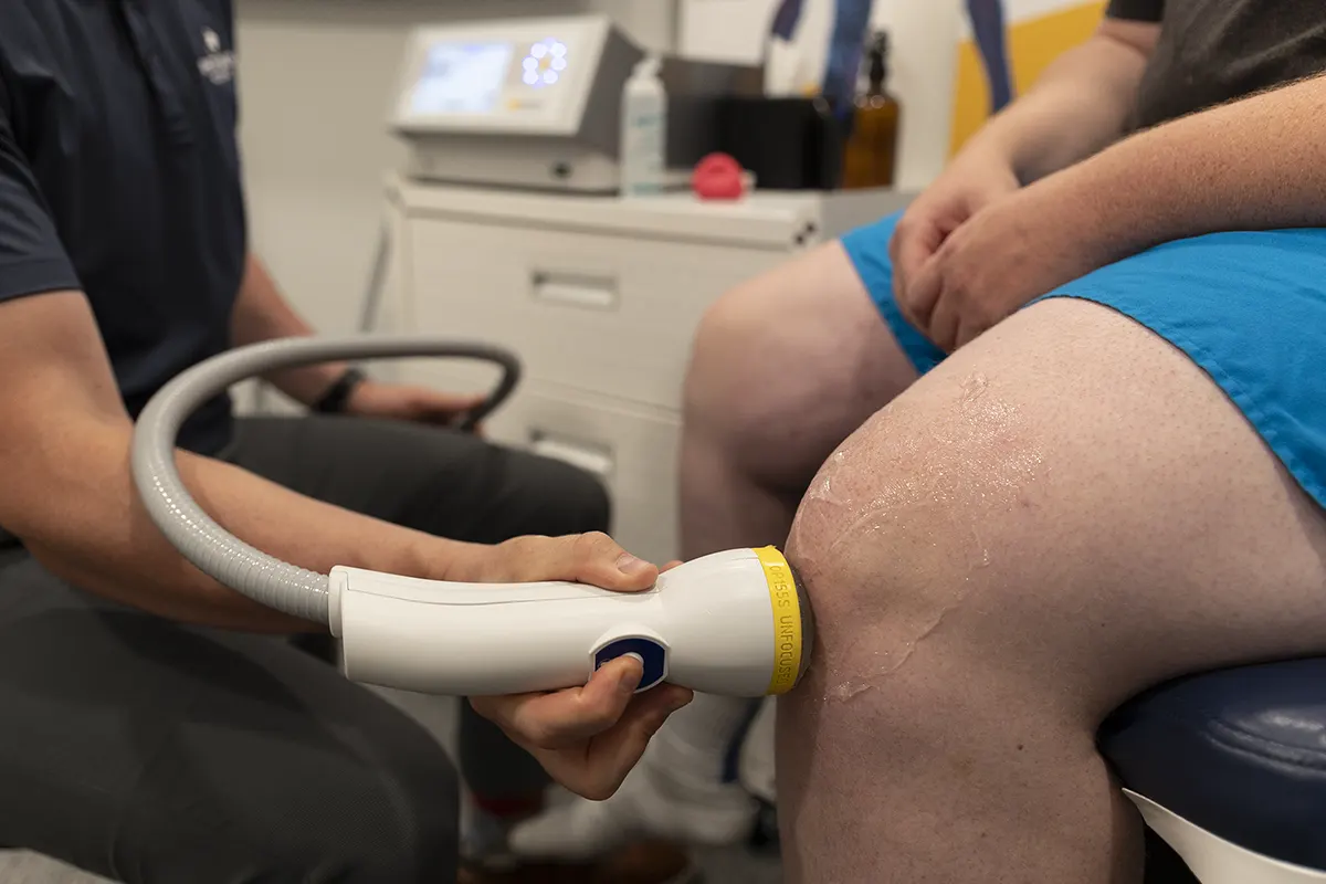 Patient receiving SoftWave therapy on the knee